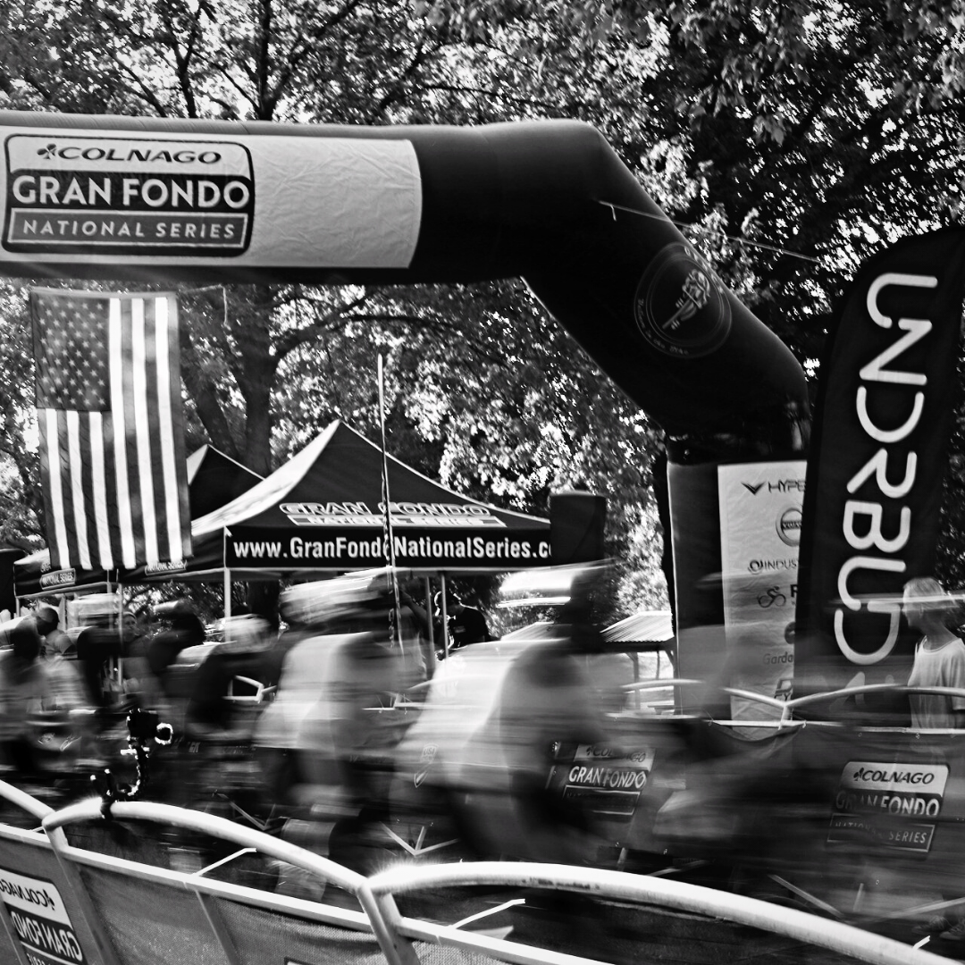 UNDRBUDR banner flying over a fast moving and blurred cyclists at Gran Fondo National Series. 